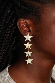 Star earrings photographed close up on a female models ear