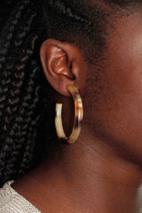 close up image of a female models ear wearing hoop earring