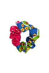 Close up image of a bright kitenge material handmade scrunchie made in uganda from locally sourced and patterned fabric